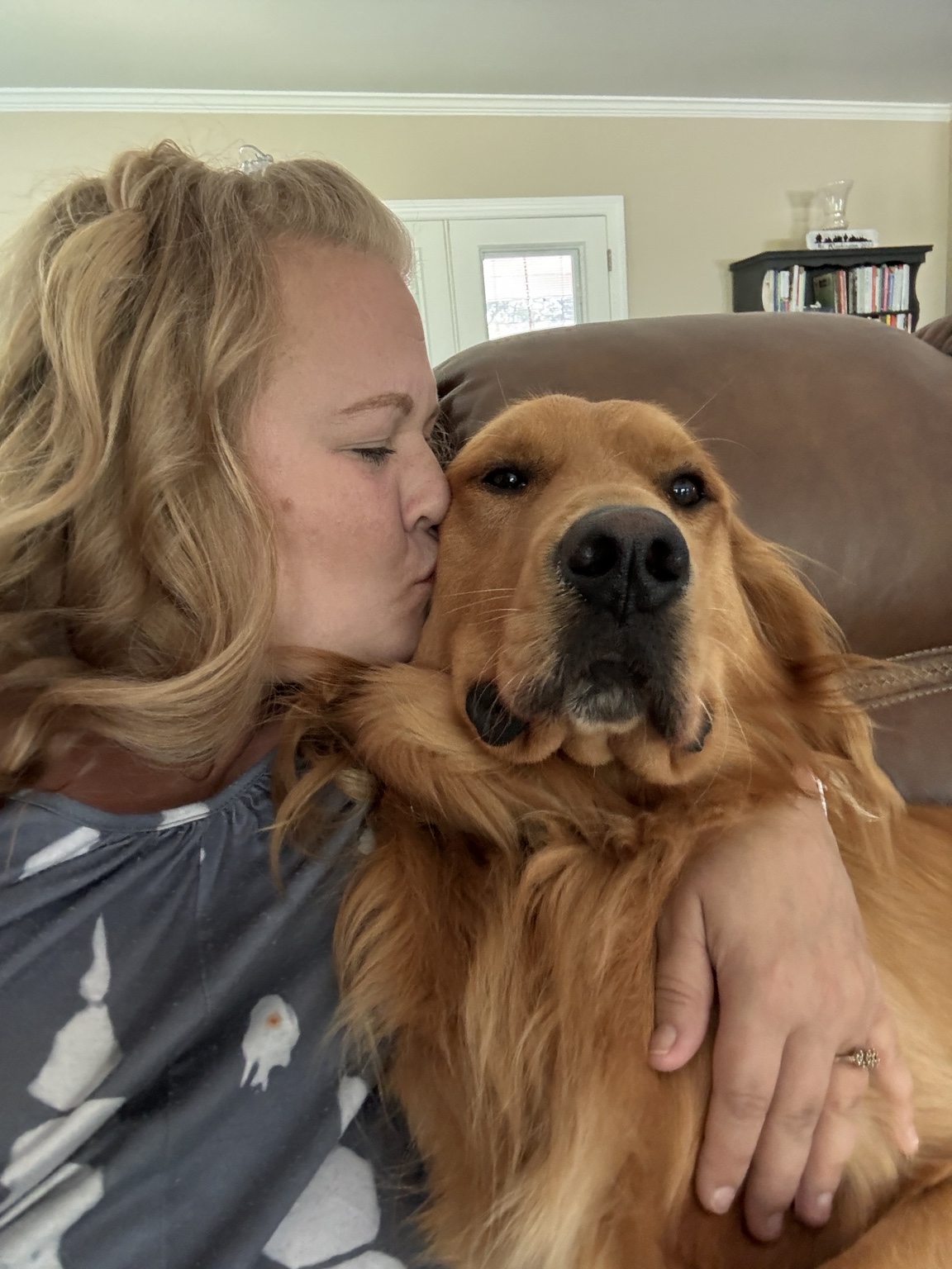 Jaymie cuddling a golden retriever